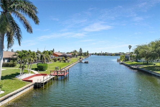 view of dock with a lawn and a water view