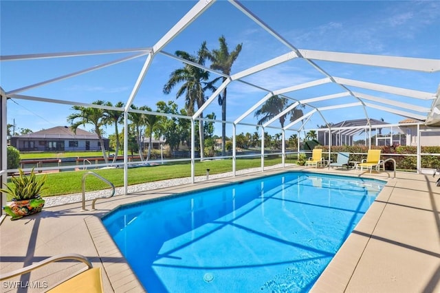 outdoor pool with glass enclosure, a patio area, and a lawn