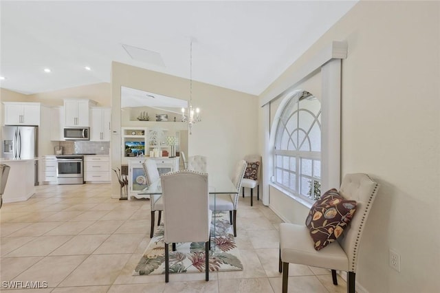 dining area featuring an inviting chandelier, lofted ceiling, and light tile patterned floors