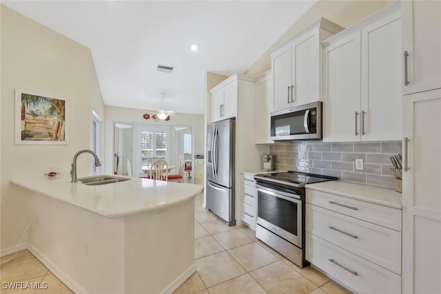 kitchen featuring visible vents, a sink, backsplash, stainless steel appliances, and white cabinets