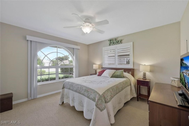 bedroom featuring a ceiling fan, light colored carpet, and baseboards