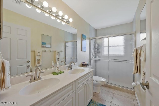 bathroom with tile patterned floors, a stall shower, toilet, and a sink