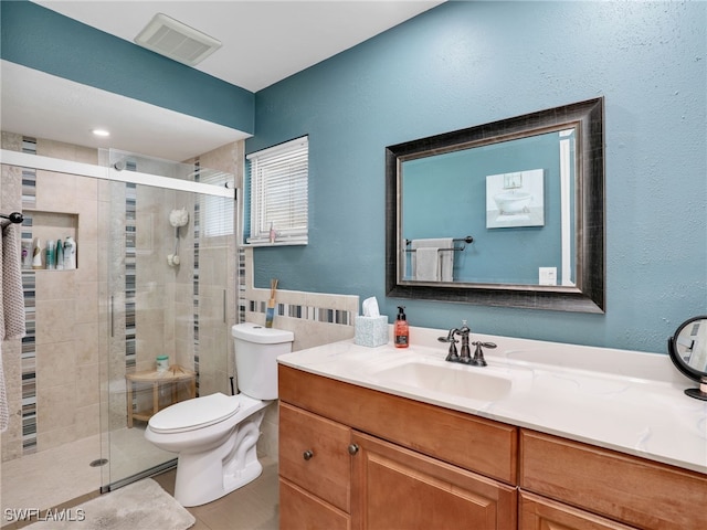 bathroom featuring visible vents, toilet, a shower stall, tile patterned flooring, and vanity