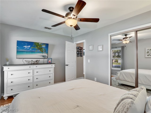 bedroom with a closet, visible vents, and ceiling fan