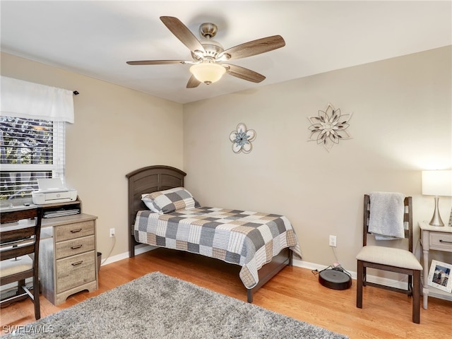 bedroom with light wood finished floors, ceiling fan, and baseboards