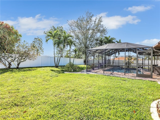 view of yard with glass enclosure, a fenced backyard, and a fenced in pool