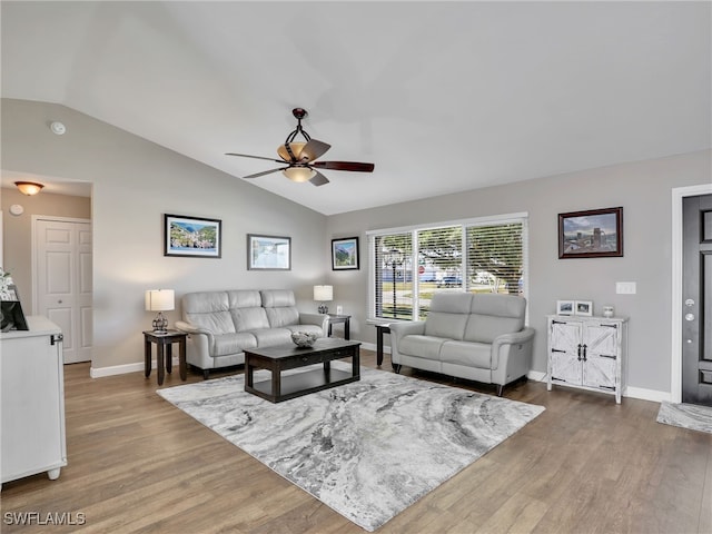 living area with baseboards, wood finished floors, lofted ceiling, and ceiling fan