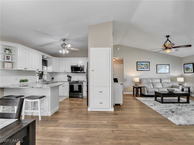 kitchen featuring ceiling fan, a peninsula, stainless steel appliances, white cabinetry, and open shelves