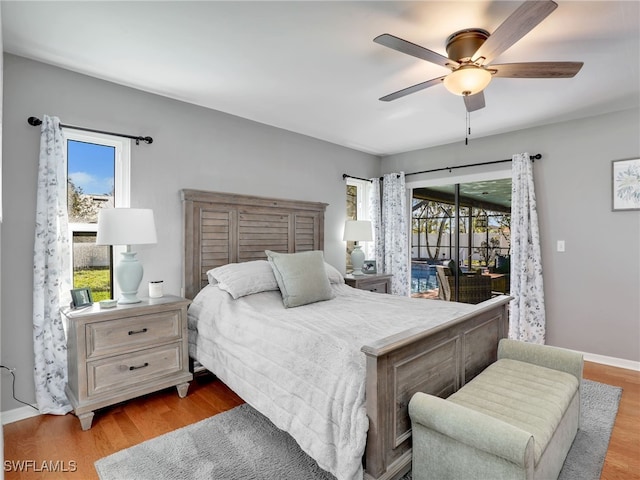 bedroom featuring multiple windows, wood finished floors, a ceiling fan, and access to outside