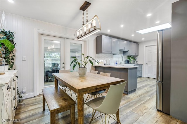 dining space featuring recessed lighting, light wood-type flooring, and crown molding