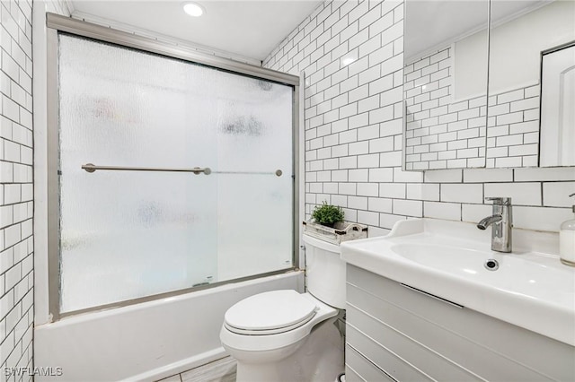 full bathroom with toilet, combined bath / shower with glass door, tile walls, decorative backsplash, and vanity