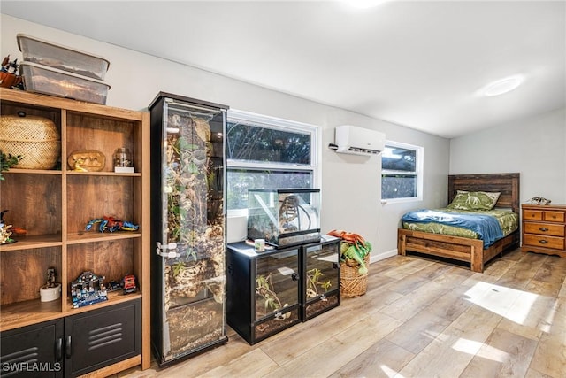 bedroom featuring a wall mounted air conditioner, wood finished floors, and vaulted ceiling