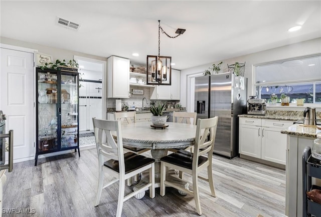 dining room with light wood finished floors, visible vents, recessed lighting, and a notable chandelier