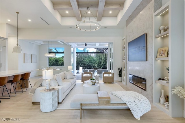 living area with beam ceiling, built in features, coffered ceiling, and a large fireplace