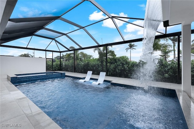 view of pool featuring glass enclosure and a pool with connected hot tub