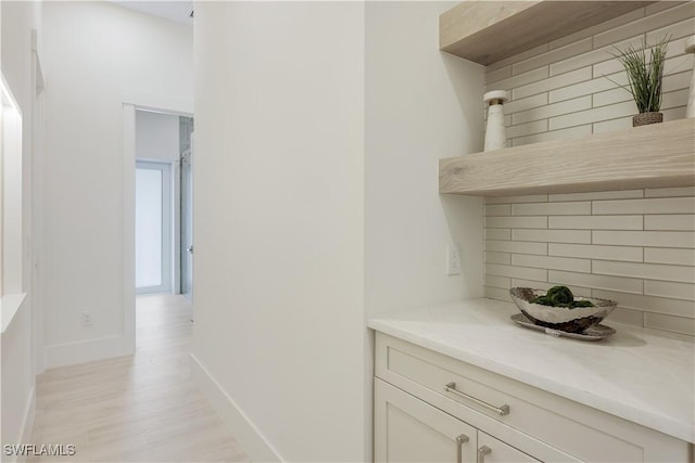 hallway with light wood-style floors and baseboards