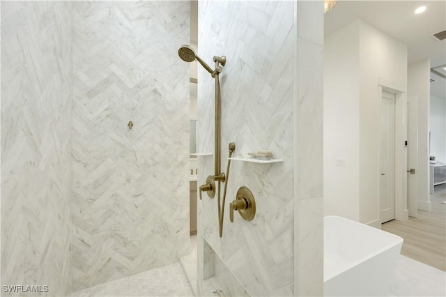 bathroom with a soaking tub, visible vents, and a marble finish shower