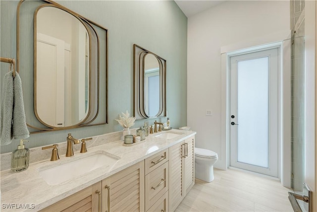 full bath with double vanity, toilet, and a sink