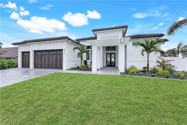 view of front of property featuring a garage, decorative driveway, a front lawn, and fence