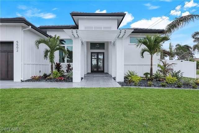 doorway to property with a lawn, french doors, a pergola, and fence