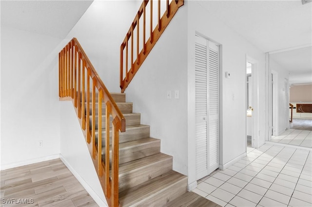 stairway featuring baseboards and wood finished floors