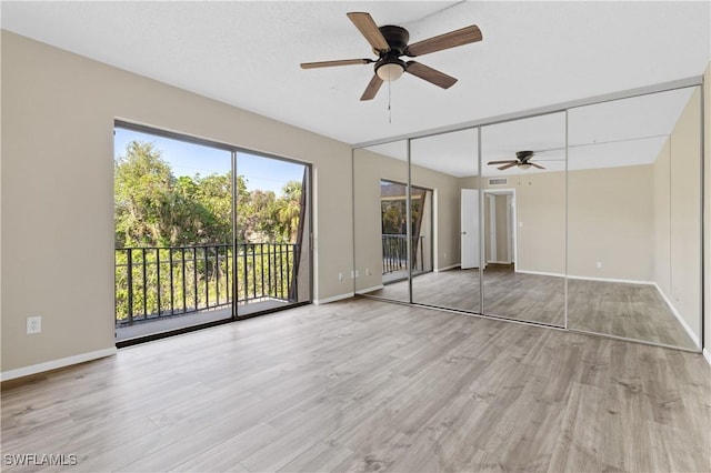 unfurnished bedroom featuring ceiling fan, light wood-style flooring, baseboards, and access to exterior