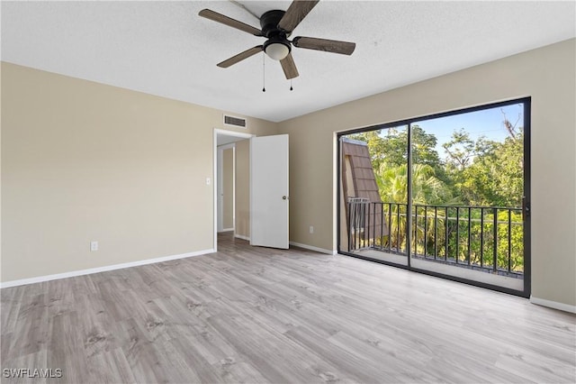 empty room featuring visible vents, ceiling fan, baseboards, wood finished floors, and a textured ceiling