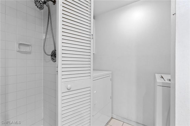 full bath with tile patterned flooring, tiled shower, and washing machine and clothes dryer