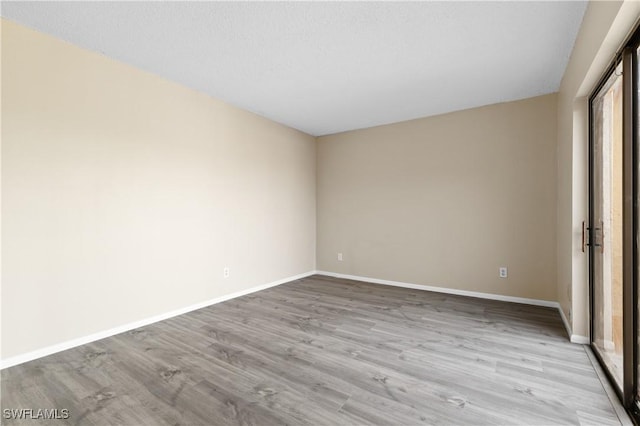 empty room featuring baseboards and wood finished floors