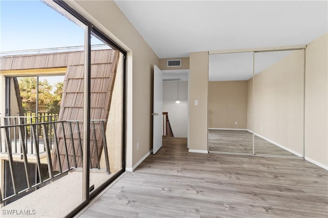 empty room with visible vents, baseboards, and wood finished floors