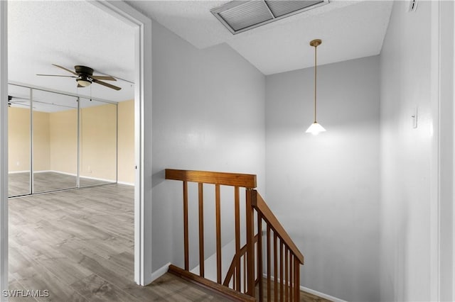 staircase with visible vents, baseboards, wood finished floors, and a ceiling fan