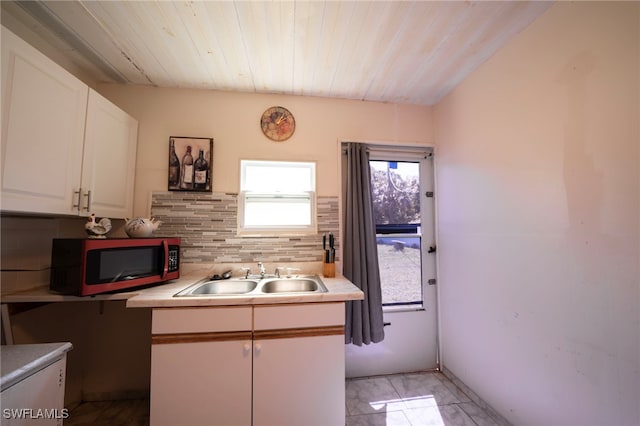 1862 Moreno Ave, Fort Myers, FL 33901 - kitchen with a sink, white cabinetry, wooden ceiling, light countertops, and decorative backsplash