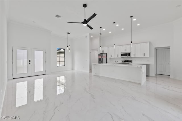 kitchen with a high ceiling, white cabinets, visible vents, and appliances with stainless steel finishes