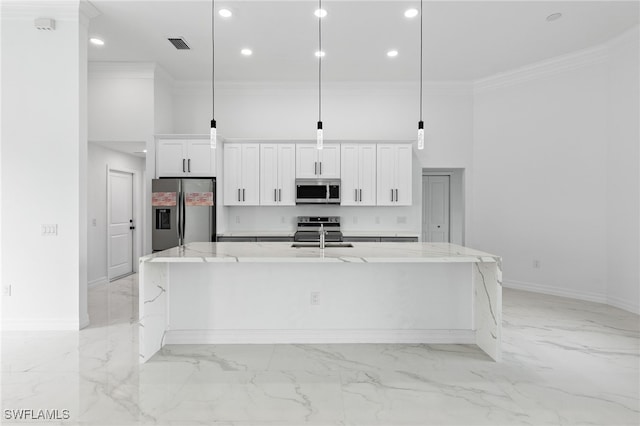 kitchen with ornamental molding, a spacious island, marble finish floor, and stainless steel appliances