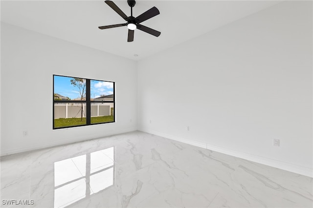 unfurnished room with baseboards, marble finish floor, and ceiling fan