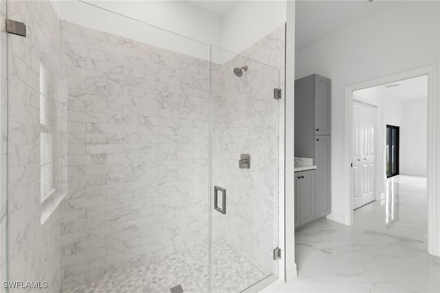 full bathroom featuring marble finish floor, a stall shower, and vanity