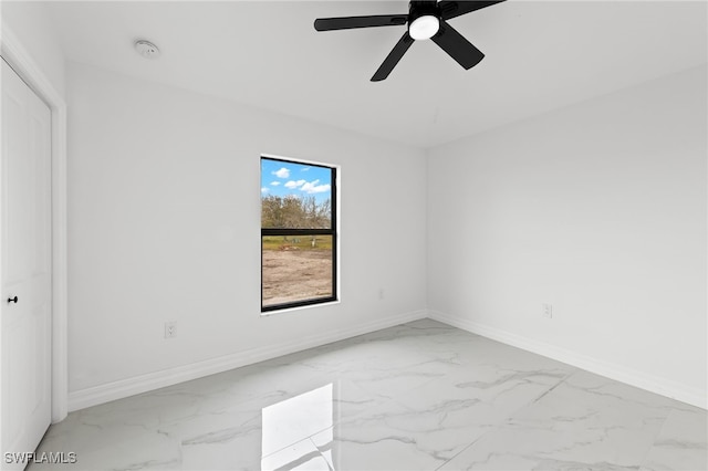 unfurnished bedroom with a ceiling fan, baseboards, and marble finish floor