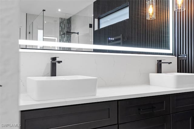 full bath featuring a sink, double vanity, and a walk in shower