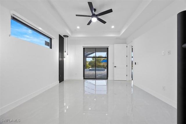 unfurnished room with recessed lighting, a tray ceiling, baseboards, and ceiling fan