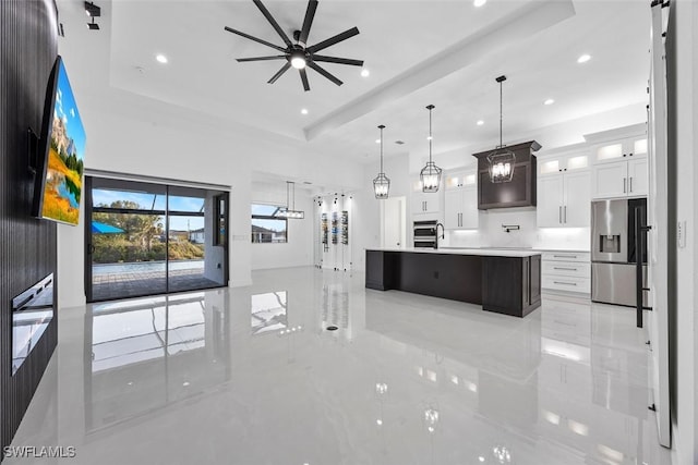 kitchen featuring marble finish floor, light countertops, a tray ceiling, and stainless steel fridge with ice dispenser