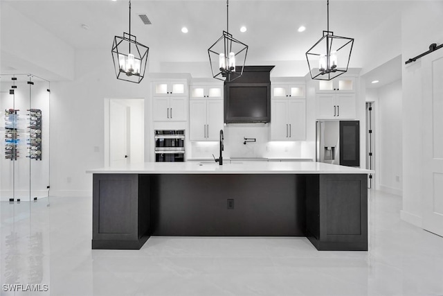 kitchen with visible vents, a sink, stainless steel appliances, light countertops, and a barn door