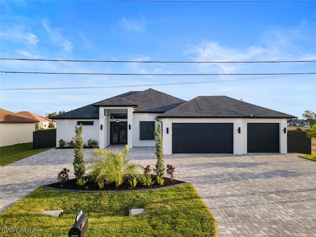 view of front facade with stucco siding, decorative driveway, fence, roof with shingles, and a garage