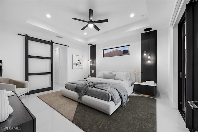 bedroom featuring a barn door, recessed lighting, visible vents, and a raised ceiling