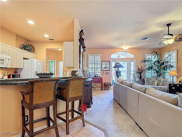 2030 Rio Nuevo Dr, North Fort Myers, FL 33917 - kitchen featuring white appliances, dark countertops, a kitchen bar, open floor plan, and a textured ceiling