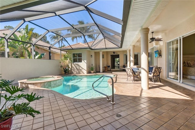 view of pool with glass enclosure, a patio, a ceiling fan, and a pool with connected hot tub