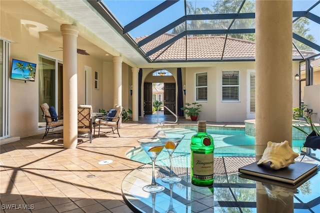 view of patio with a lanai, a ceiling fan, and an outdoor pool