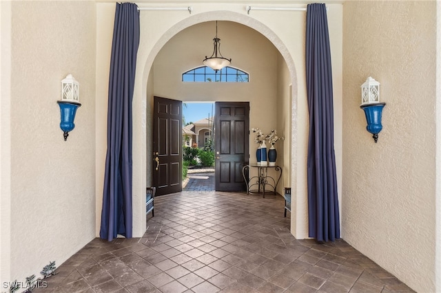 entrance foyer with arched walkways and a textured wall