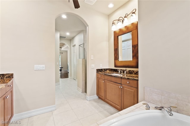 bathroom featuring vanity, a ceiling fan, baseboards, tile patterned floors, and a washtub