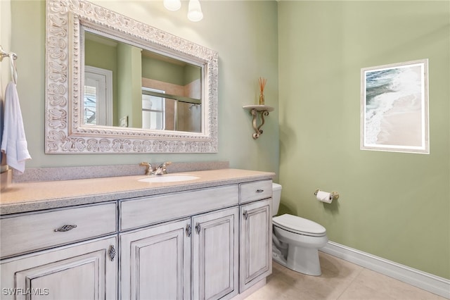 bathroom featuring baseboards, toilet, tile patterned floors, an enclosed shower, and vanity