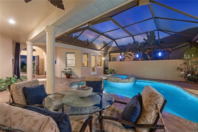 view of swimming pool featuring glass enclosure, a patio area, and a pool with connected hot tub